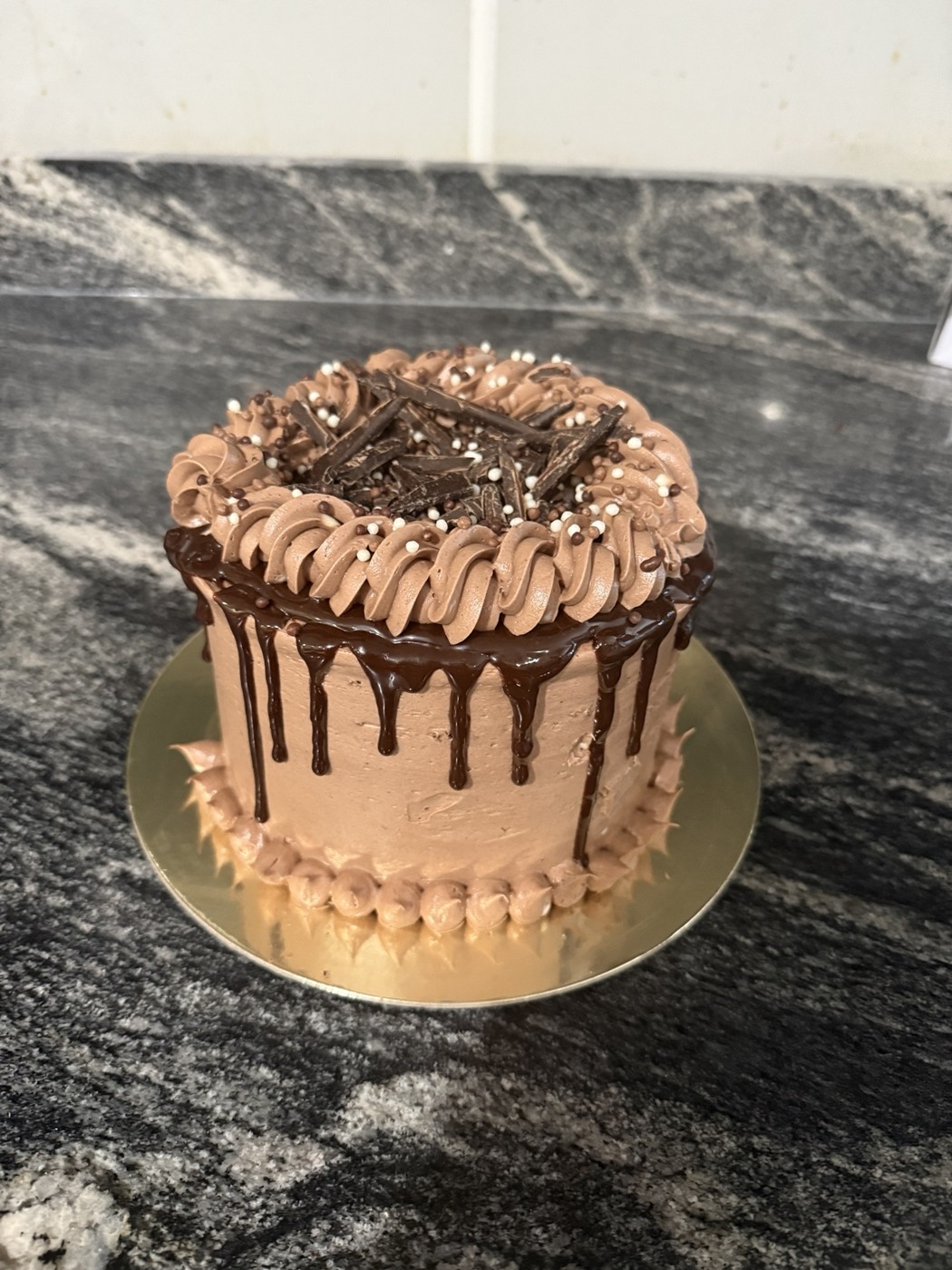 Alfonso’s chocolate drip cake with piped frosting and chocolate decorations